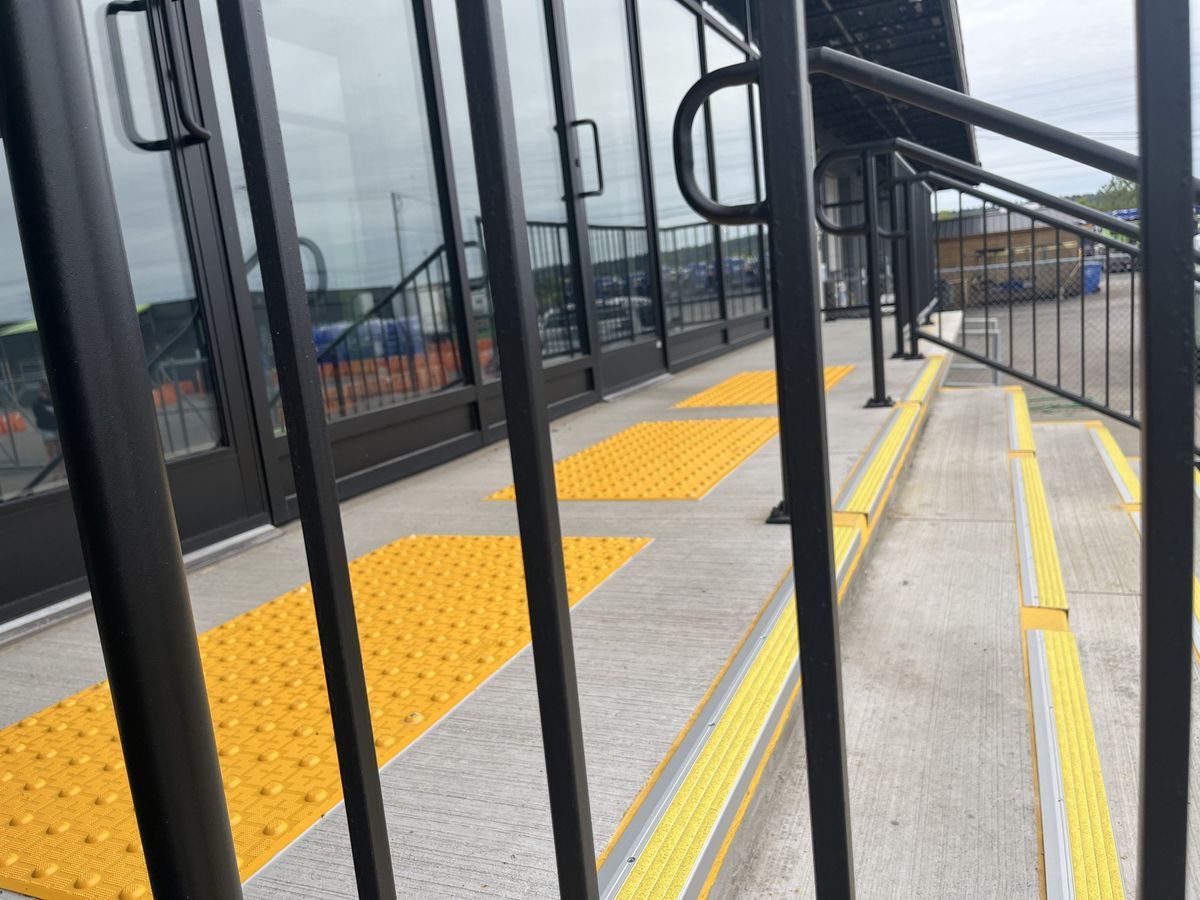 Close view of tactile access tiles at the top landing and anti-slip nosing strips on the treads