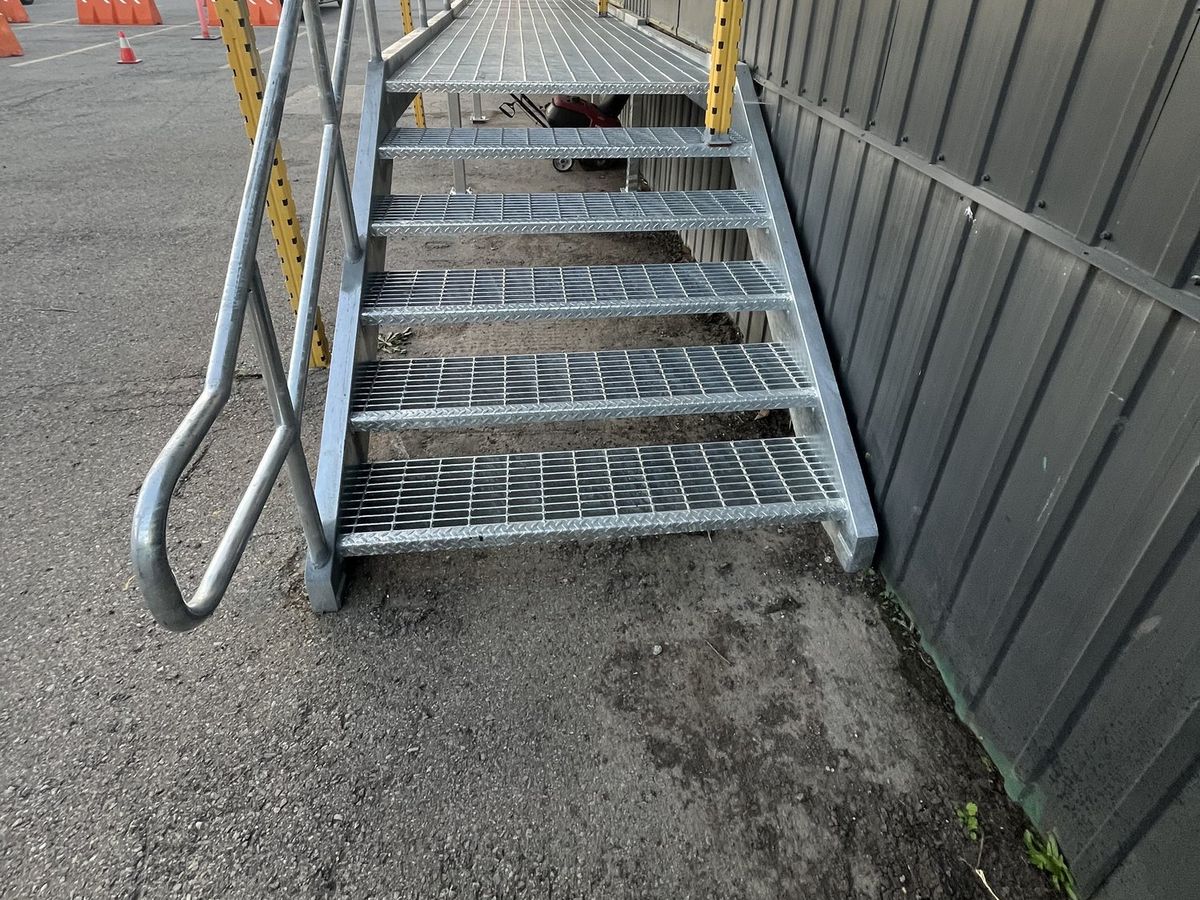 Open-grate metal stair with no contrast nosing on the treads, before the retrofit