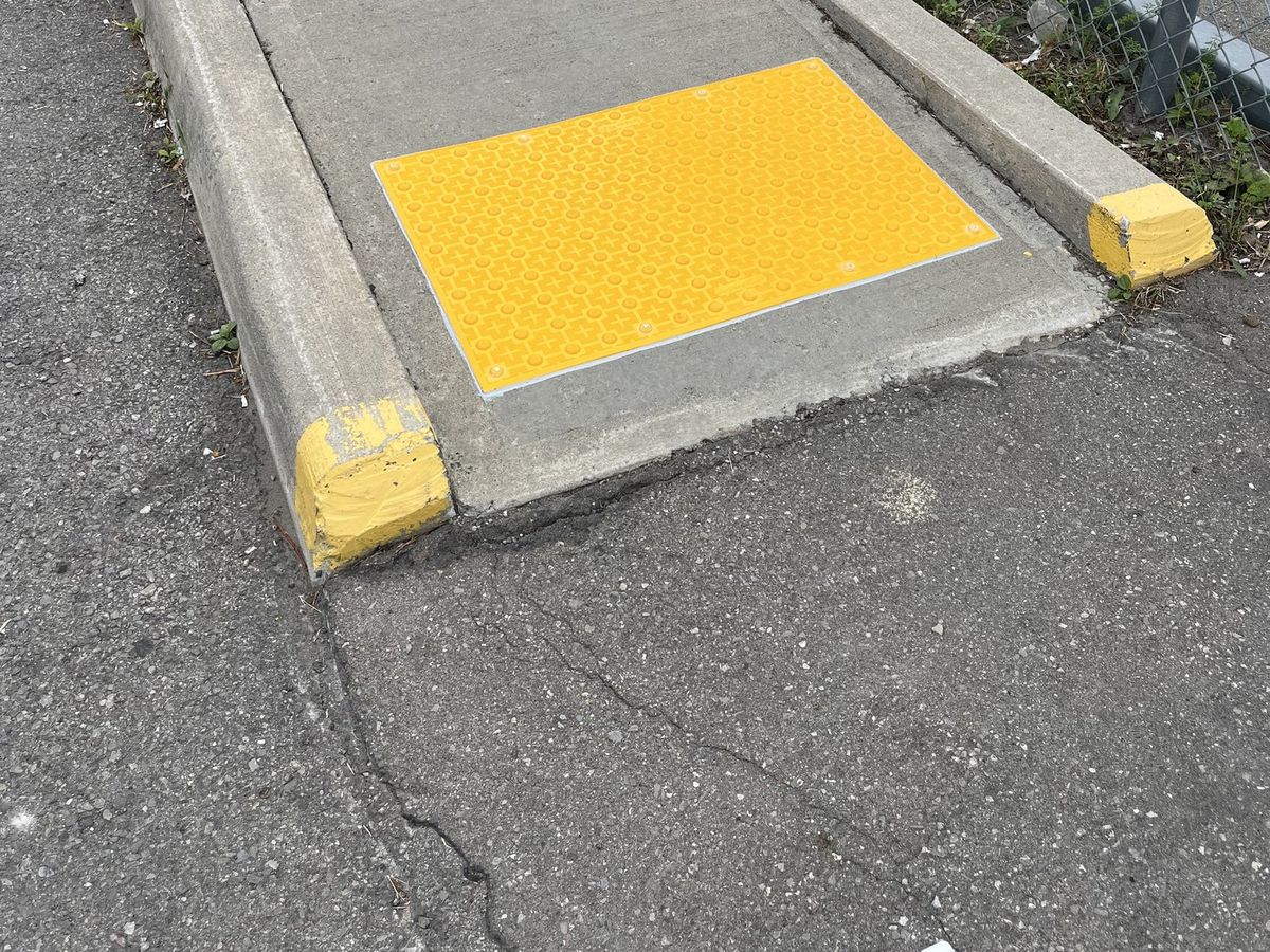 Yellow tactile access tile installed at the walkway approach
